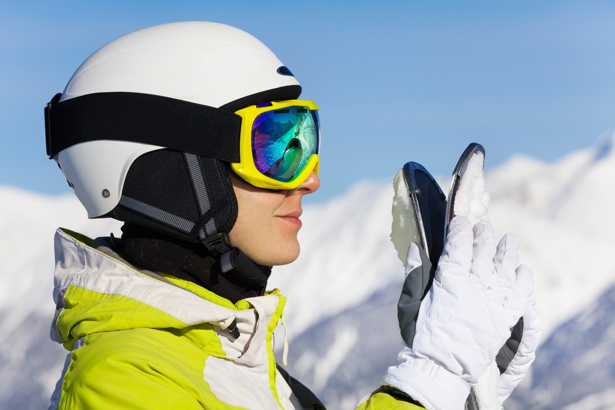 Woman wearing yellow ski goggles and white helmet