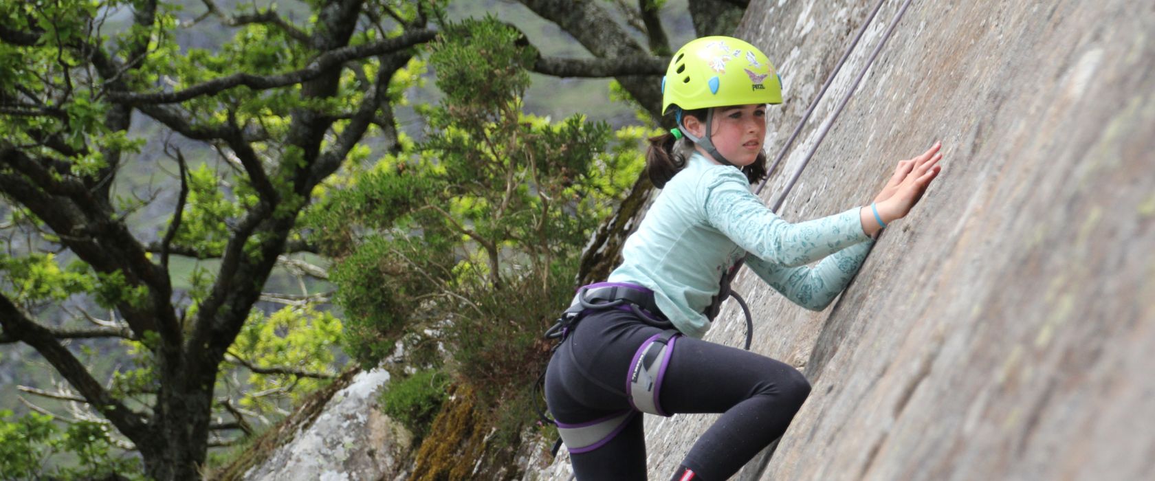 person climbing a rock wall