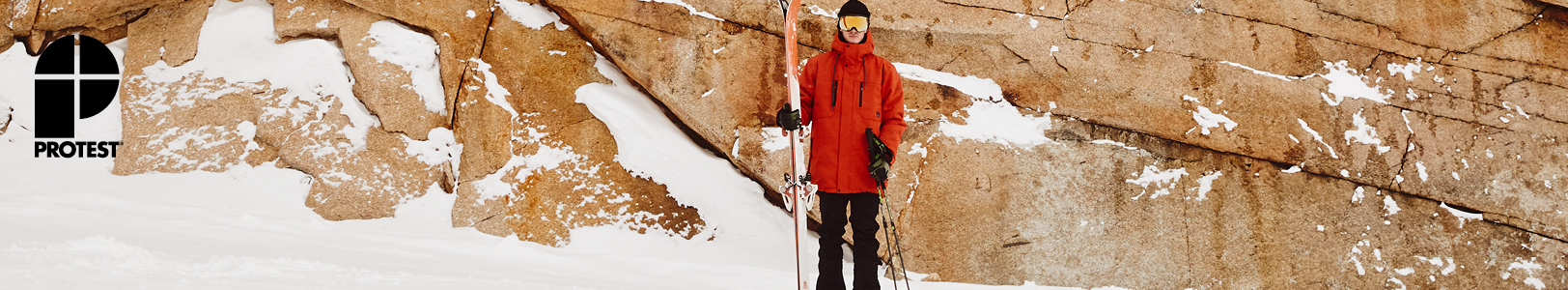 Protest header. A person wearing Protest ski clothing holding their skis 