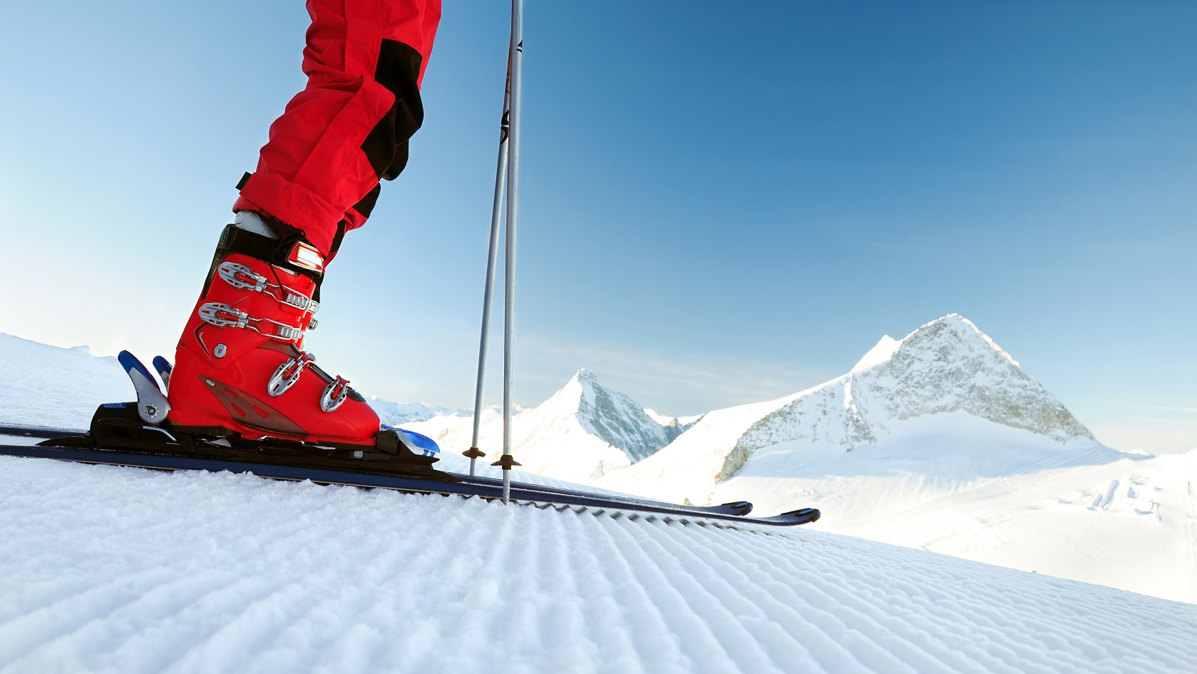 A person wearing red ski boots 