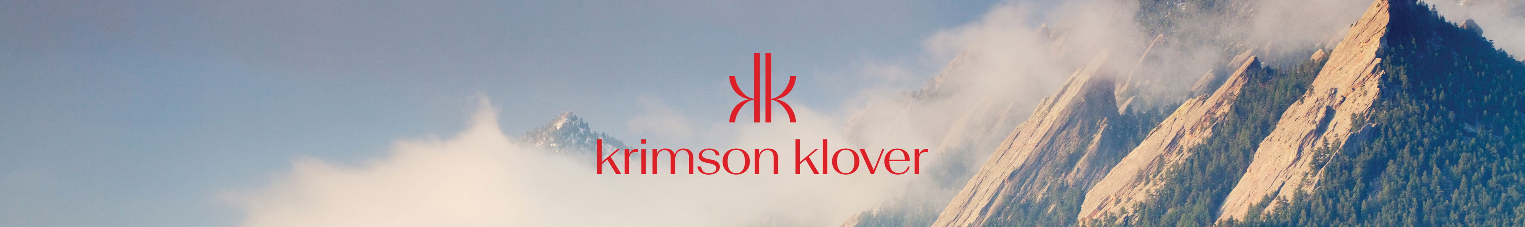 Krimson Klover header image, their logo over an image of mountains