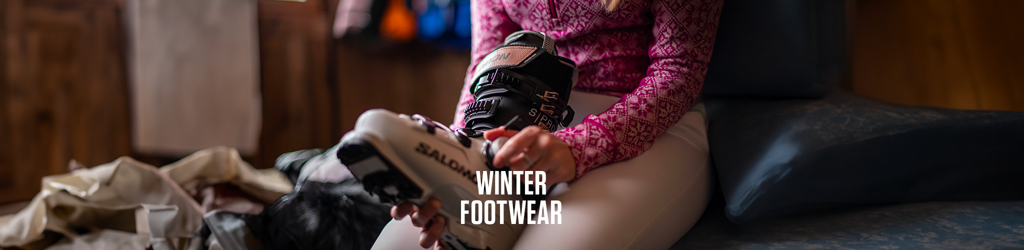 Shop winter footwear. A person adjusting their ski boots 