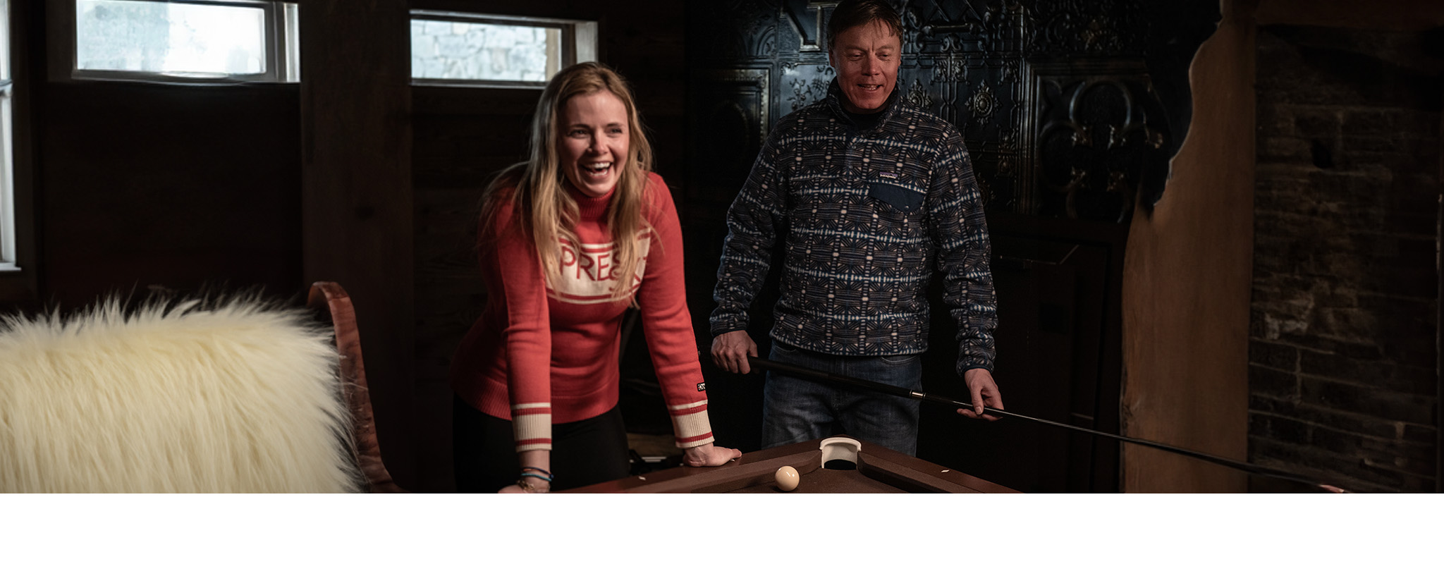 Shop for apres. A man and woman wearing fleeces in a ski chalet