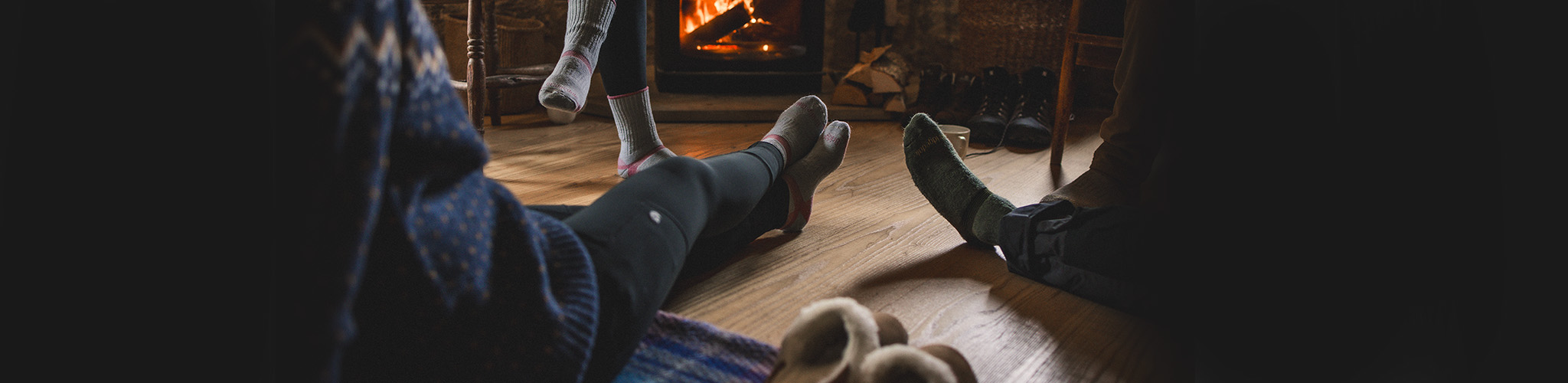 Shop Gifts under £50. People sat around the fire in a chalet. 