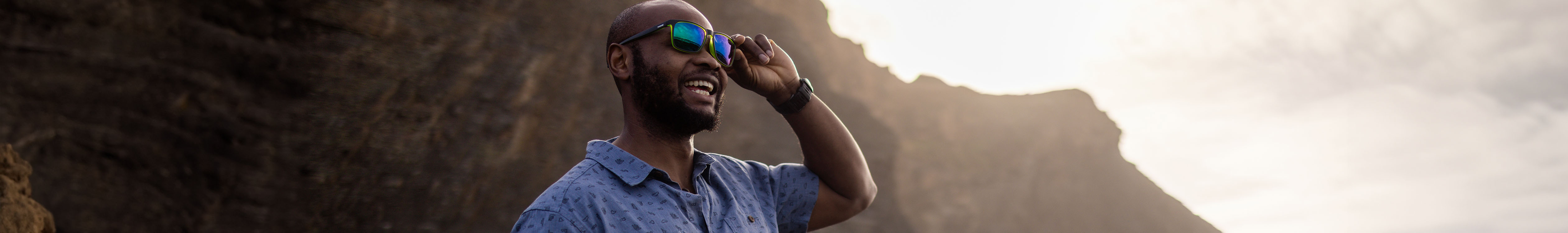 Accessories summer styles. A man is smiling and touching his summer glasses