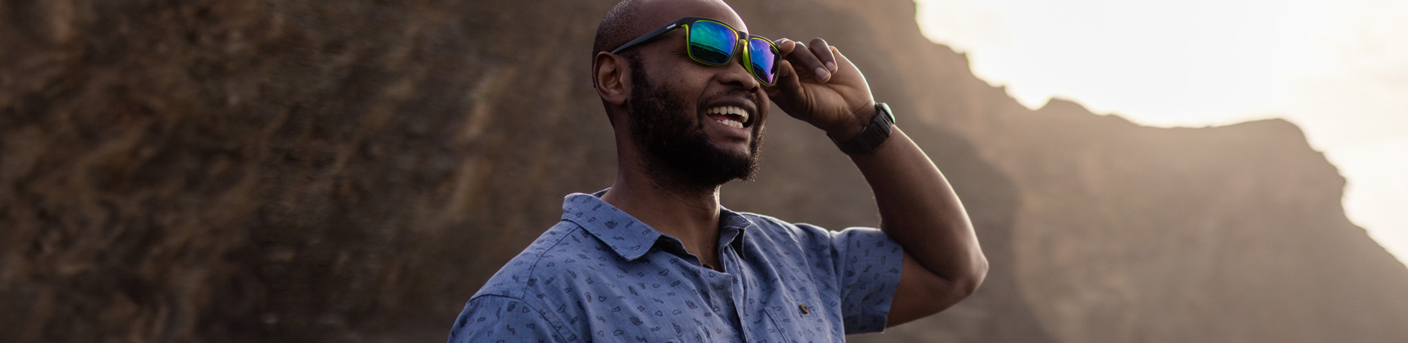 Accessories summer styles. A man is smiling and touching his summer glasses