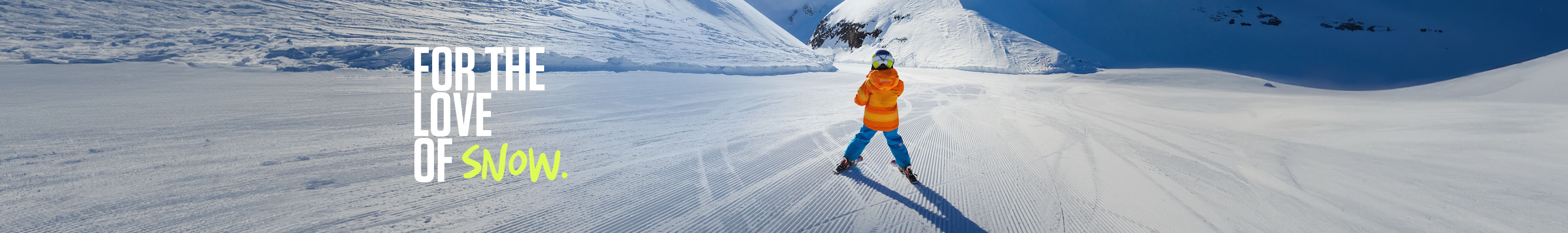 Shop kids new season. Kid in orange jacket and blue troursers skiing on the piste