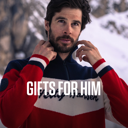 Shop gifts for him. A man adjusting his Helly Hansen mid-layer outside a chalet