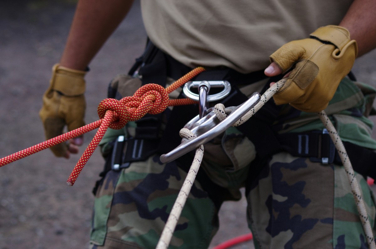 A man with ropes tied to his harness