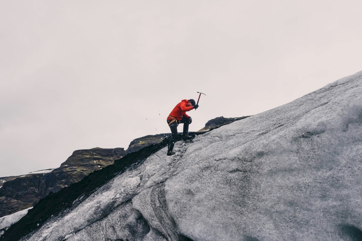 A person with an ice axe up an icy climb 