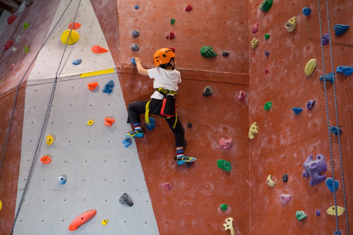 A child wearing a helmet on a climbing wall 