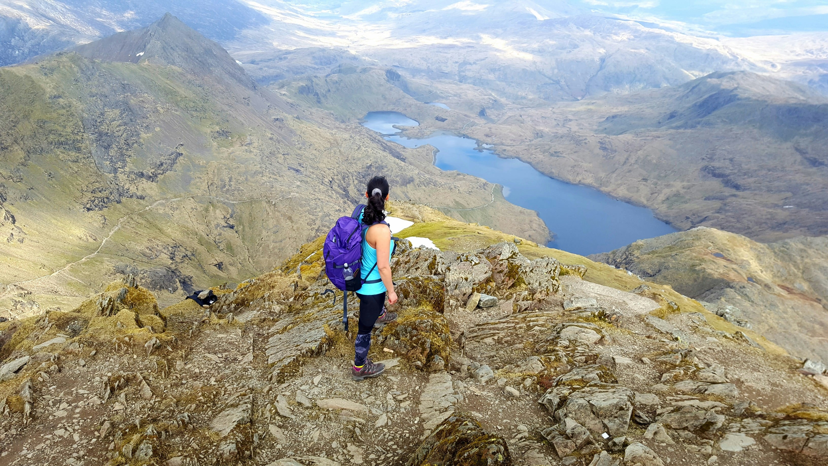 A woman stood on Snowdon, looking out to the lake below 