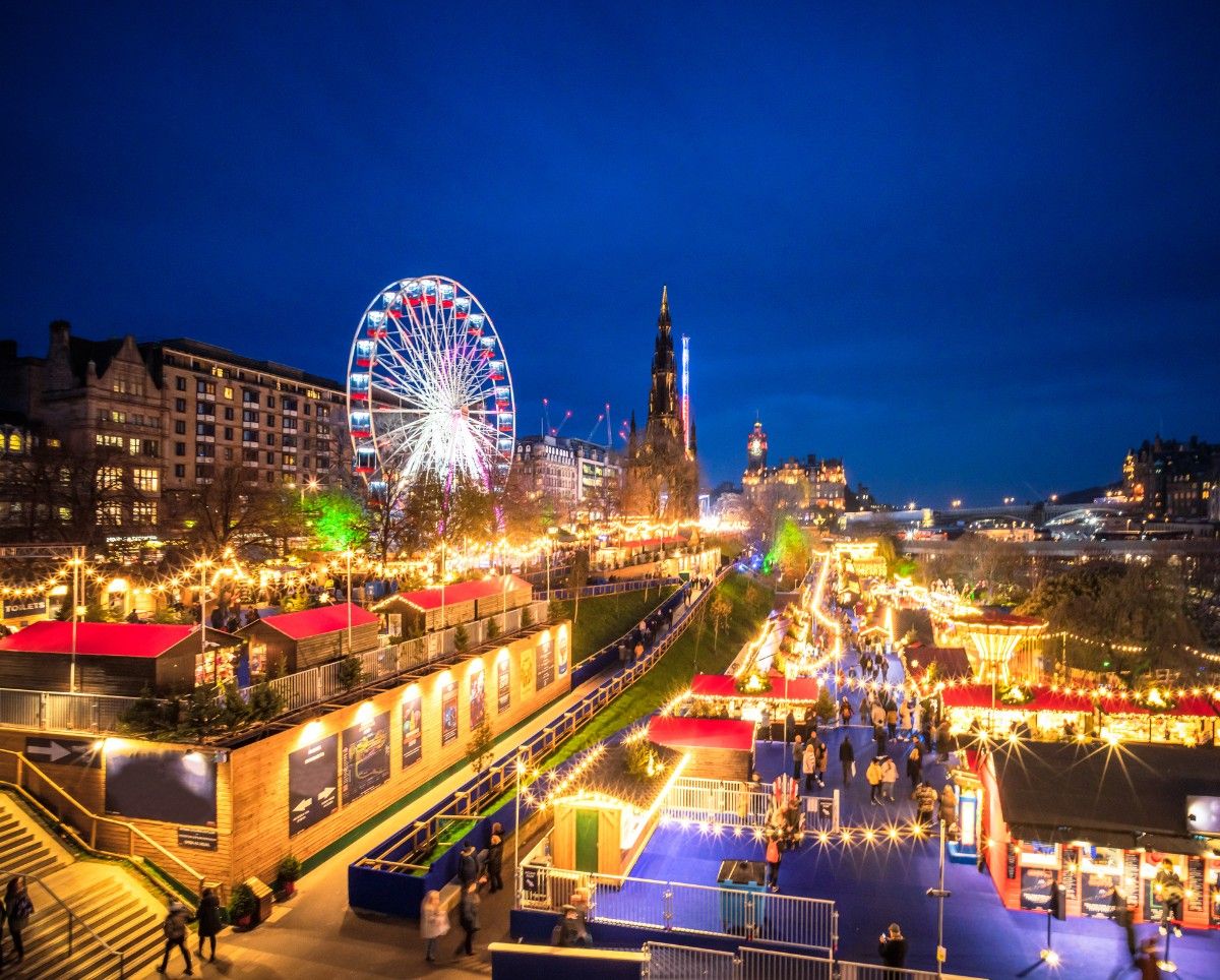 Edinburgh Christmas markets on Princes Street, all lit up in the evening 