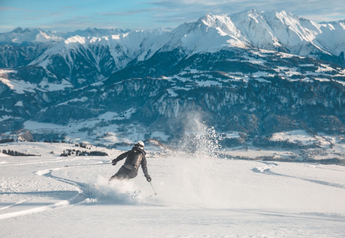 A woman carving down the piste on her skis at Laax Ski Resort