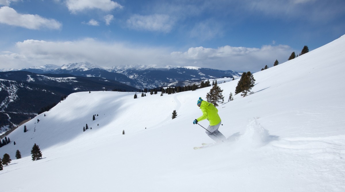 A person carving down the mountain on their skis in Vail 