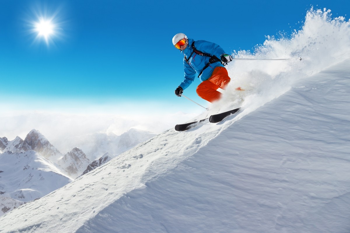 A man skiing in a blue ski jacket