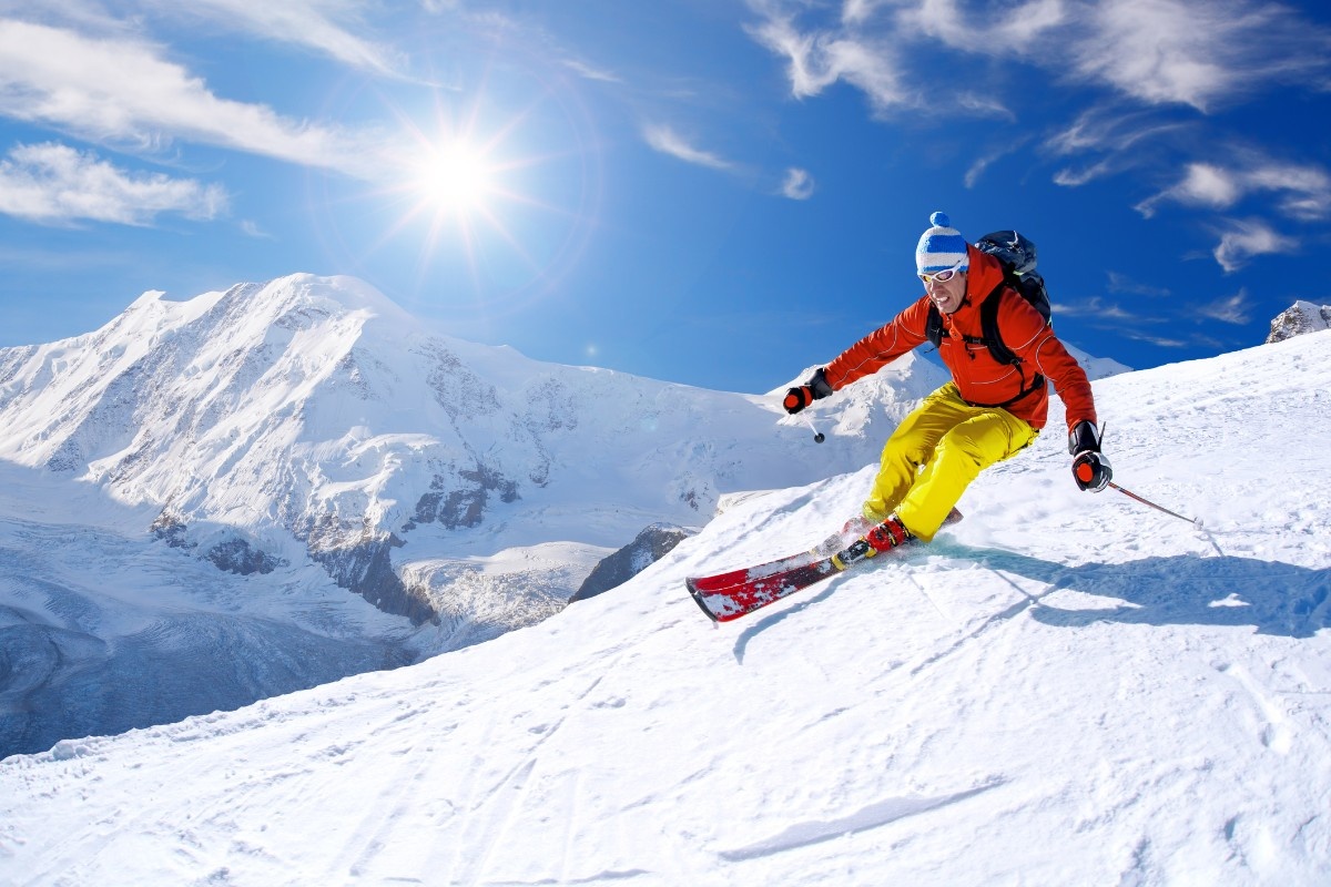 A man skiing down the piste in a red ski jacket 