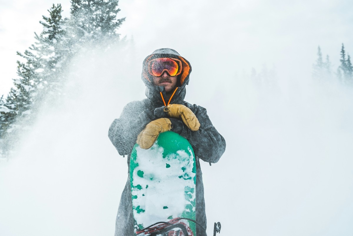 A man wearing ski mitts in the snow 