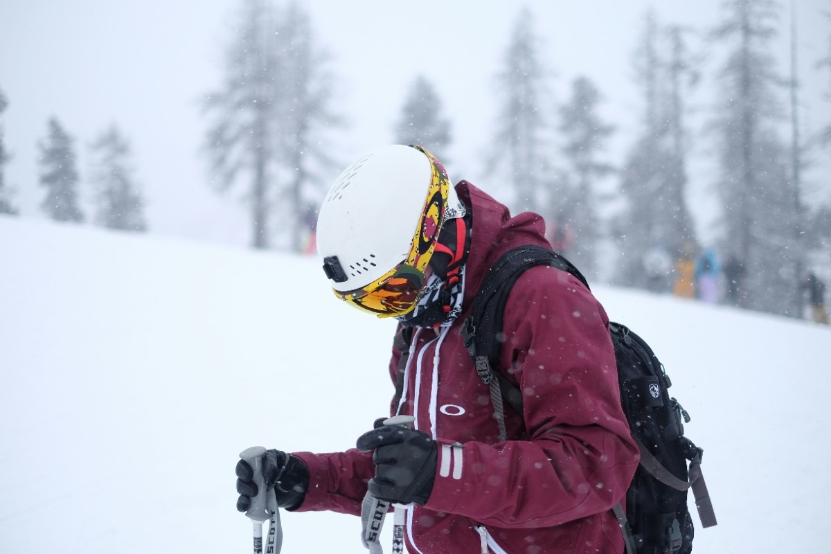 A person holding their ski poles wearing ski gloves on a snowy mountain 