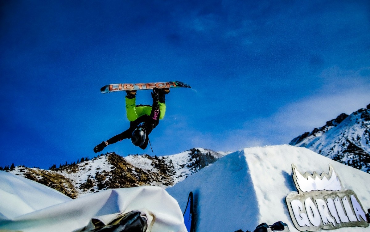 A snowboarder performing an upside down trick 