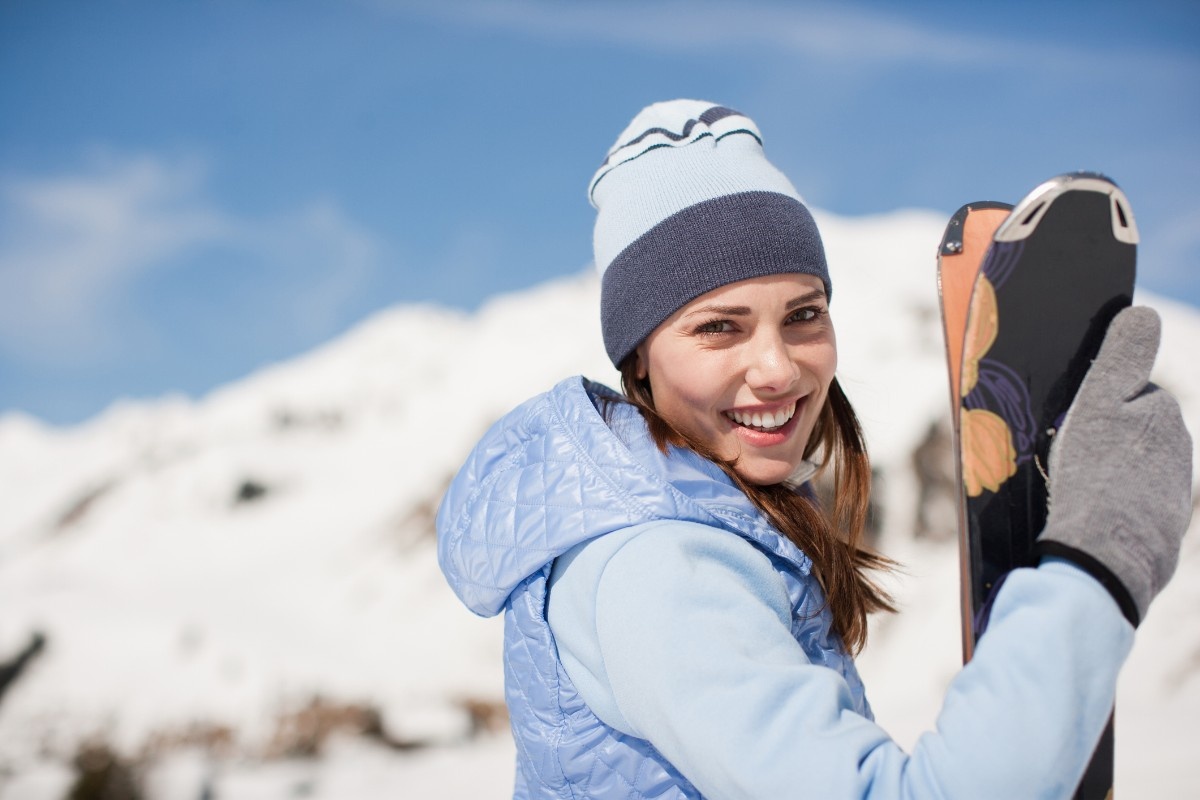 A woman wearing a blue ski jackets holfing her skiis